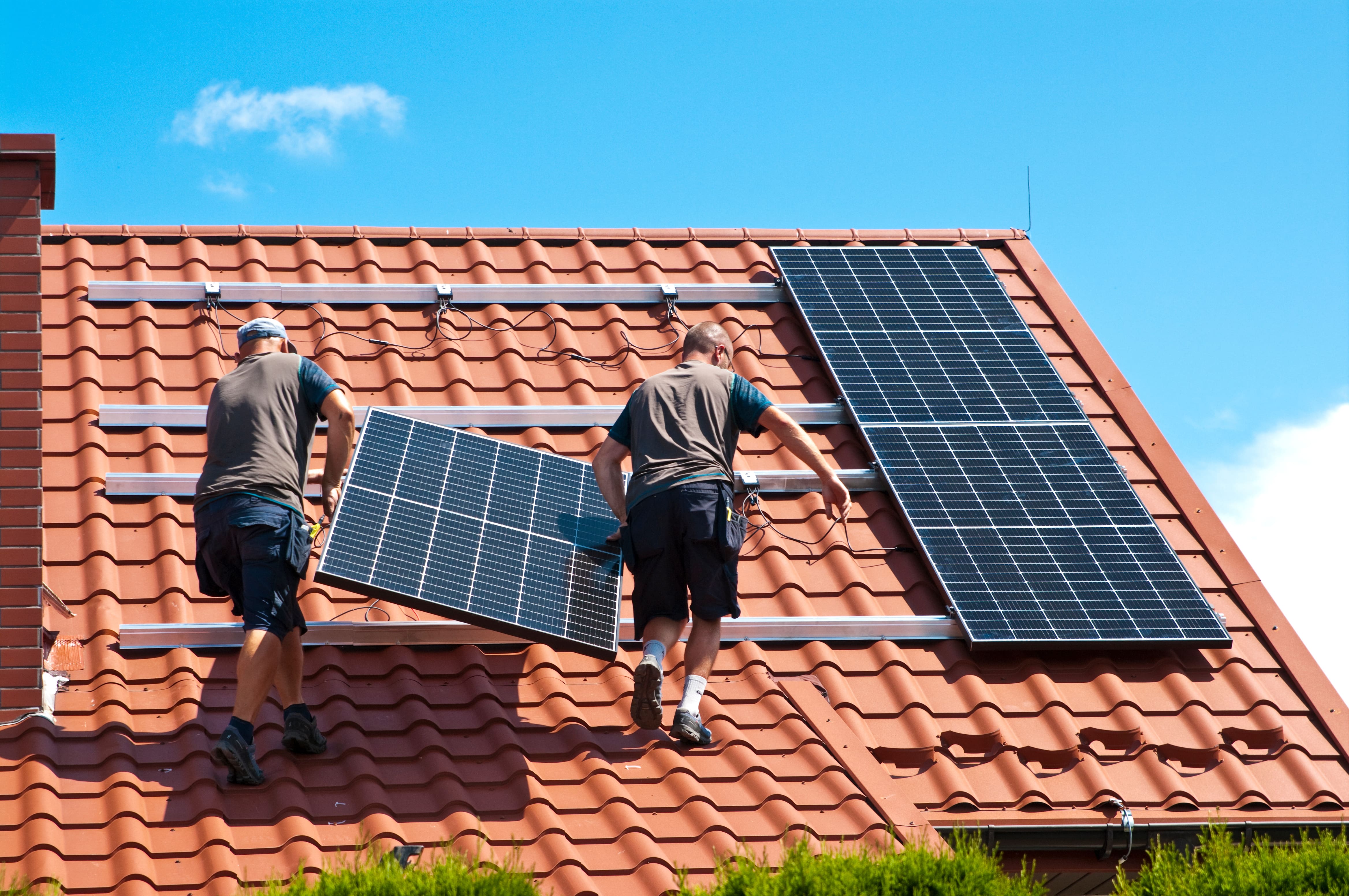 Photo de personnes en train d'installer des panneaux photovoltaïques