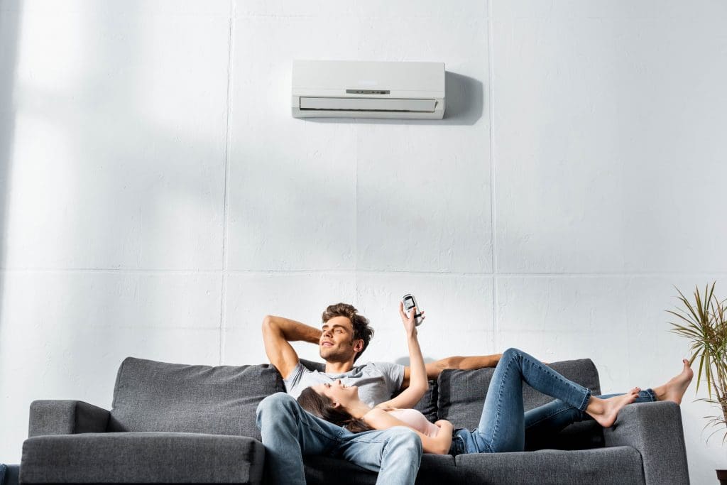 Photo d'un couple allongé sous une climatisation réversible